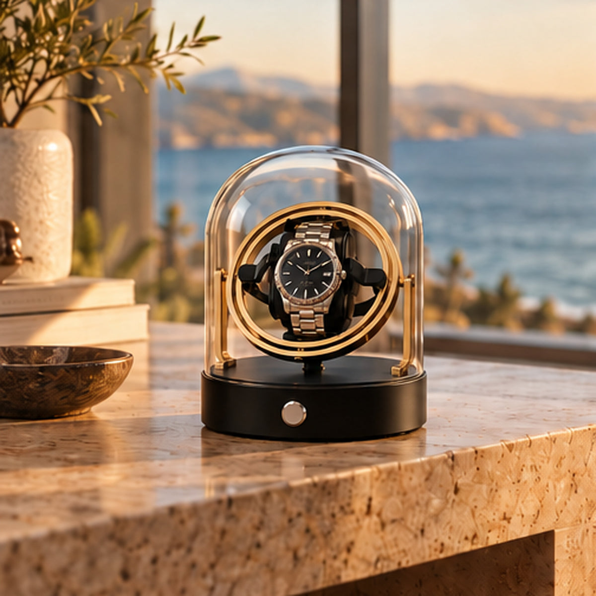 Remontoir Montre Gyroscopique 1 Place – Cloche en Verre – posé sur un plan en granit devant une baie vitrée avec vue mer