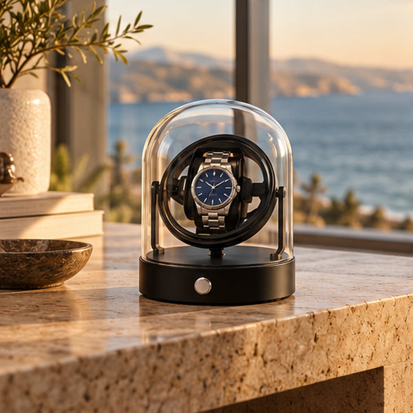 Remontoir Montre Gyroscopique 1 Place – Cloche en Verre – posé sur un plan en granit devant une baie vitrée avec vue mer