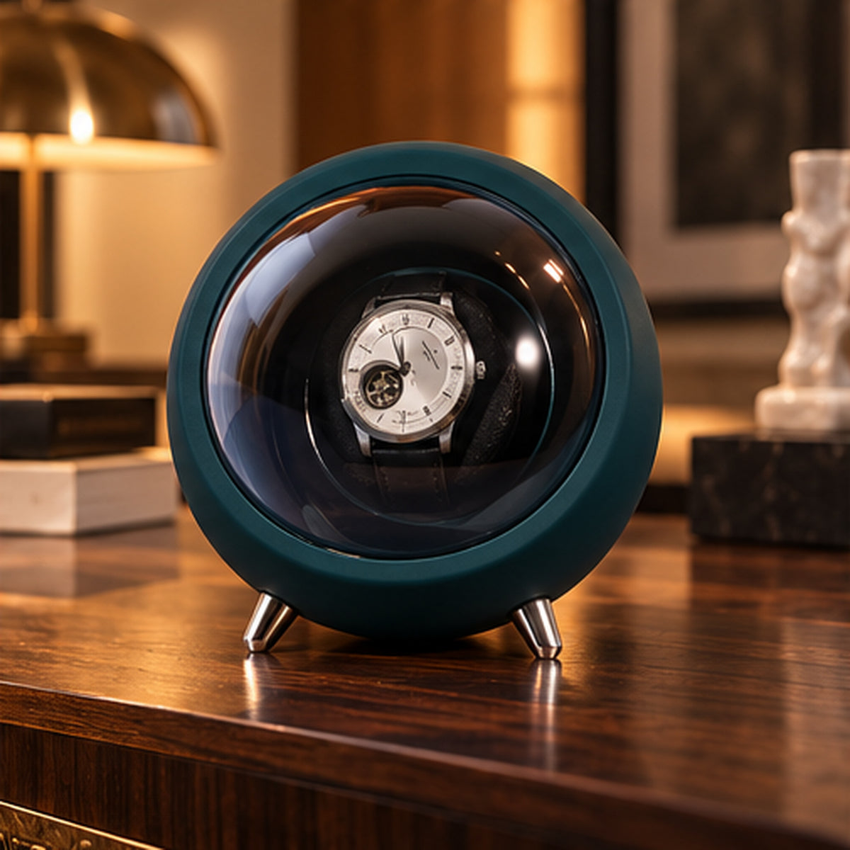 Remontoir Montre Automatique 1 Place – Design Rond – sphère vert sapin posée sur un meuble près d'une lampe
