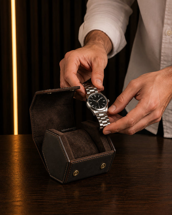 Main déposant une montre automatique sur le coussin d'un étui de voyage 1 montre – Complications Paris